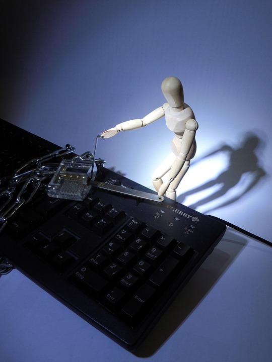 A pose reference doll picking a lock on top of a keyboard